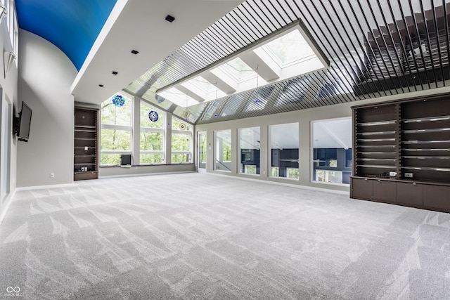12469 Springmill Rd, Carmel, IN 46032 - unfurnished living room with a skylight, high vaulted ceiling, carpet flooring, and baseboards