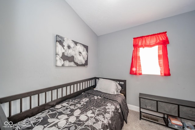 carpeted bedroom featuring vaulted ceiling and baseboards