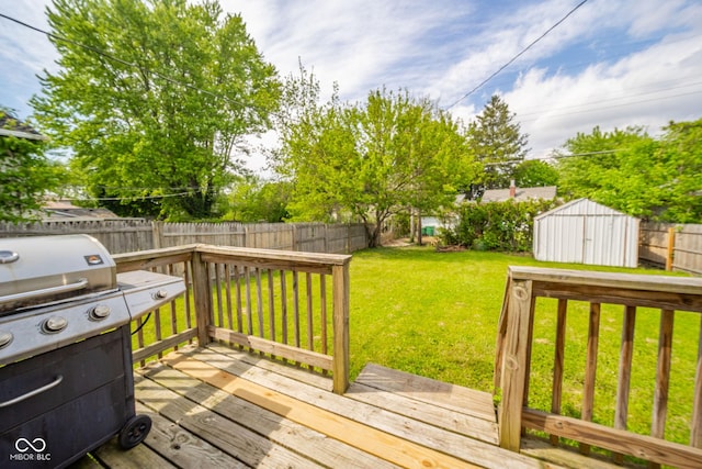 wooden terrace featuring a shed, an outbuilding, and area for grilling