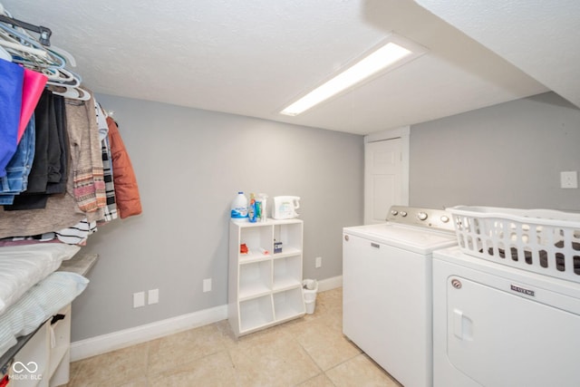 laundry room with independent washer and dryer, baseboards, and light tile patterned floors