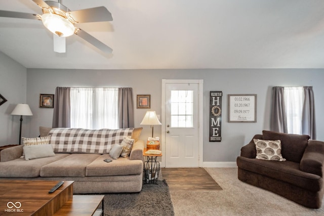 living area featuring carpet floors, ceiling fan, and baseboards