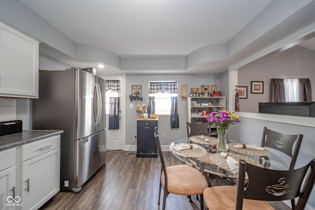 dining space with dark wood-type flooring and baseboards