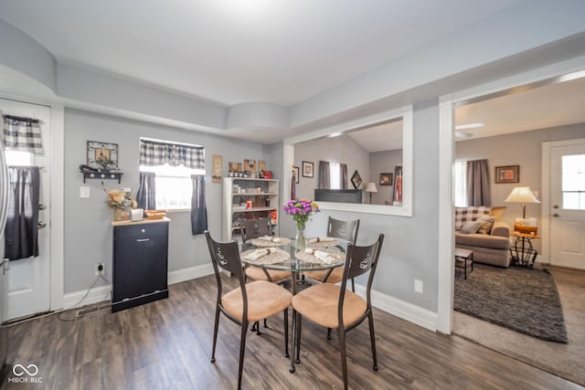 dining space featuring dark wood-style flooring and baseboards