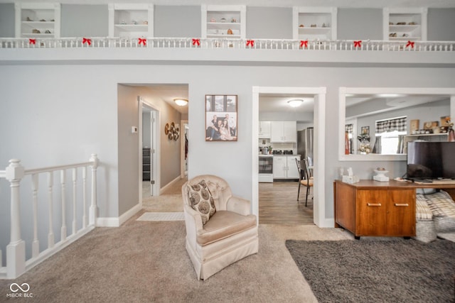 corridor with light colored carpet and an upstairs landing