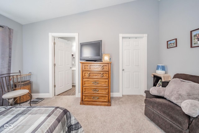 bedroom with lofted ceiling, light colored carpet, and baseboards