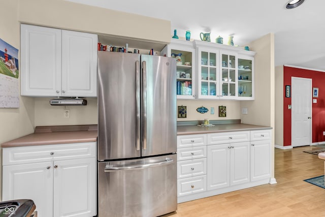 610 N Forest Rd, Crawfordsville, IN 47933 - kitchen with freestanding refrigerator, light wood-type flooring, glass insert cabinets, white cabinets, and light countertops