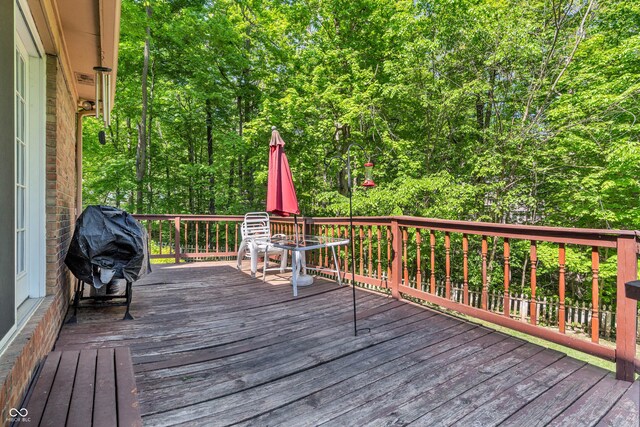 610 N Forest Rd, Crawfordsville, IN 47933 - wooden terrace with grilling area, outdoor dining space, and a wooded view