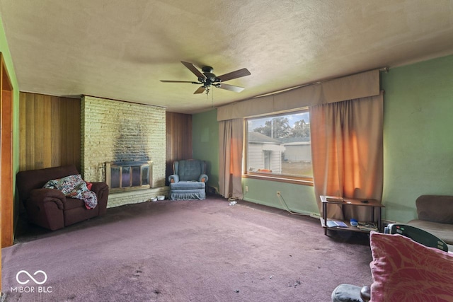 2840 W 12th St, Anderson, IN 46011 - sitting room featuring ceiling fan, a fireplace, carpet floors, a textured ceiling, and wooden walls