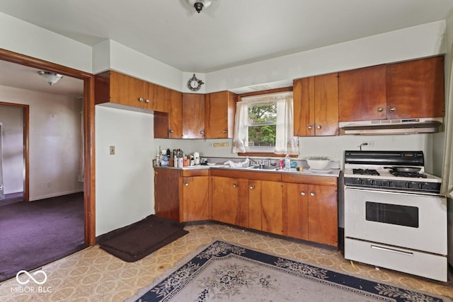 2840 W 12th St, Anderson, IN 46011 - kitchen with gas range gas stove, under cabinet range hood, brown cabinets, and light countertops