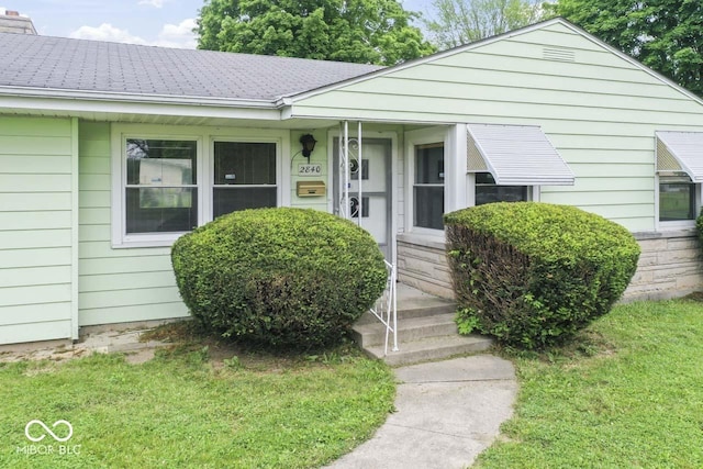 2840 W 12th St, Anderson, IN 46011 - view of front of home featuring roof with shingles, a front lawn, and a chimney