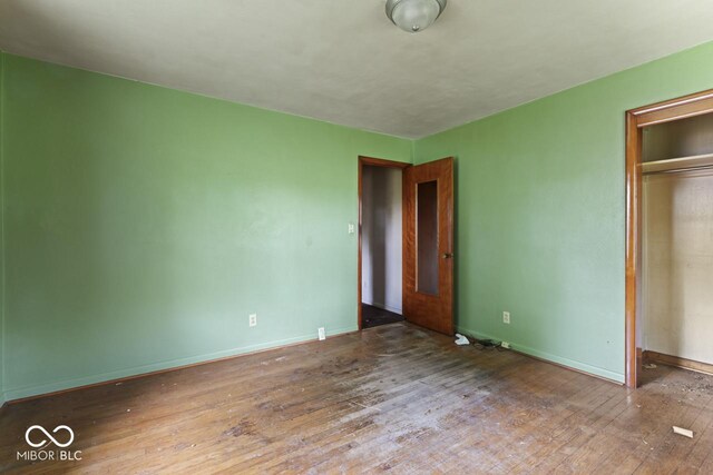 2840 W 12th St, Anderson, IN 46011 - unfurnished bedroom featuring hardwood / wood-style floors, a closet, and baseboards