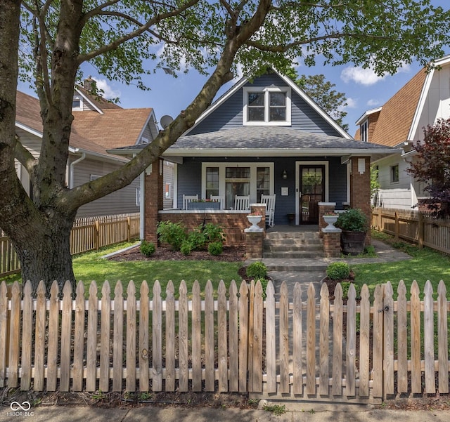 1132 Evison St, Indianapolis, IN 46203 - view of front facade featuring a porch, a fenced front yard, and roof with shingles