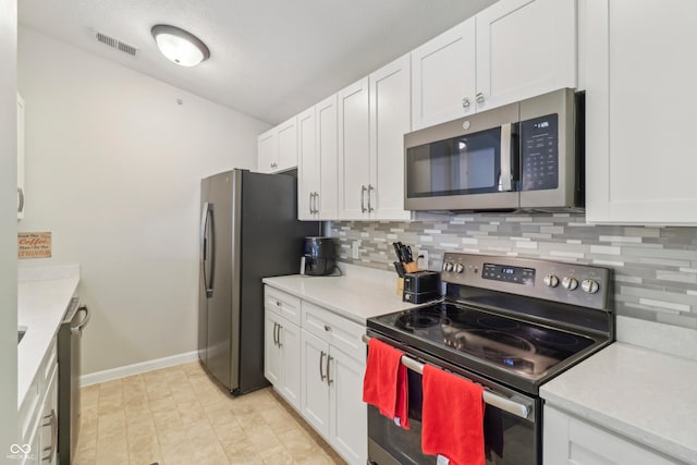 8910 Hunters Creek Dr Unit 207, Indianapolis, IN 46227 - kitchen with appliances with stainless steel finishes, tasteful backsplash, baseboards, and white cabinetry