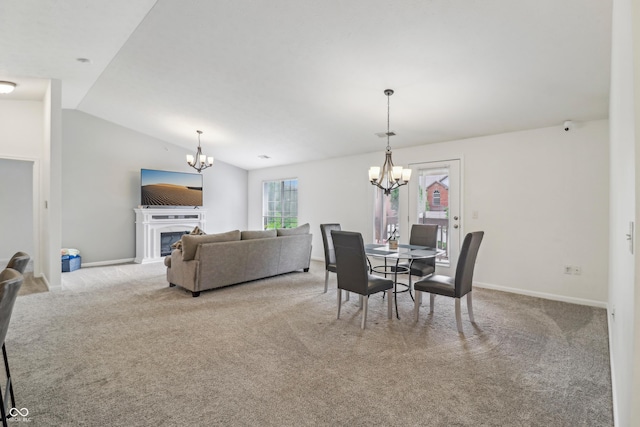 8910 Hunters Creek Dr Unit 207, Indianapolis, IN 46227 - carpeted dining area with a chandelier, vaulted ceiling, a fireplace, and baseboards