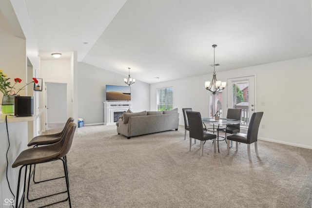 8910 Hunters Creek Dr Unit 207, Indianapolis, IN 46227 - dining room with a chandelier, carpet, vaulted ceiling, a fireplace, and baseboards