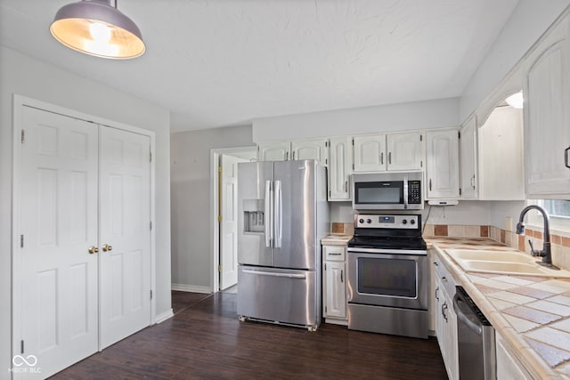 522 E County Road 1000 S, Clayton, IN 46118 - kitchen featuring stainless steel appliances, tile countertops, a sink, white cabinets, and dark wood-style flooring