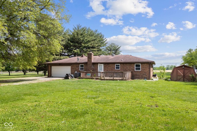 522 E County Road 1000 S, Clayton, IN 46118 - back of property featuring a storage unit, driveway, a lawn, a garage, and brick siding