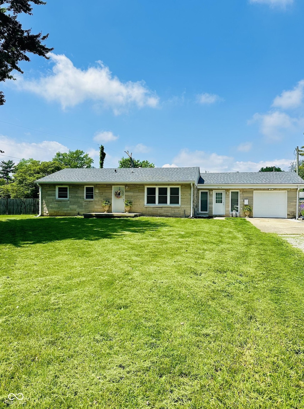 3414 Rost Dr, Columbus, IN 47203 - ranch-style home featuring an attached garage and driveway