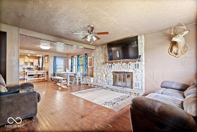 671 W 350 N, Shelbyville, IN 46176 - living room with a textured ceiling, ceiling fan, hardwood / wood-style floors, and a fireplace