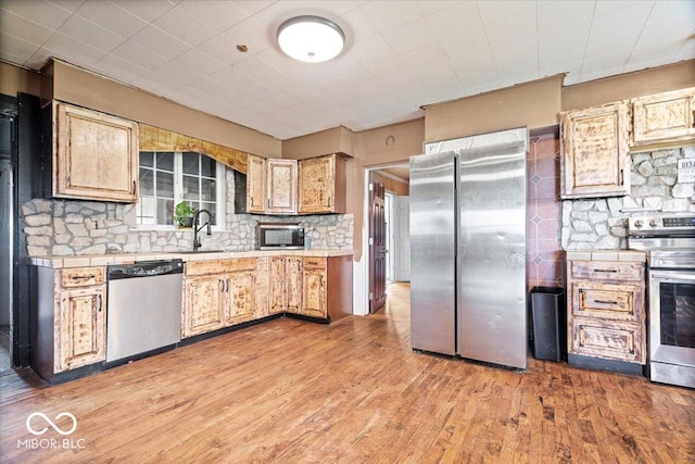 671 W 350 N, Shelbyville, IN 46176 - kitchen with stainless steel appliances, a sink, tile countertops, tasteful backsplash, and light wood-style flooring