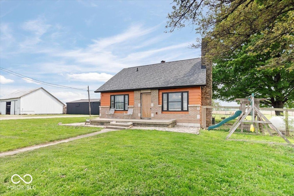 671 W 350 N, Shelbyville, IN 46176 - view of front facade with brick siding, a shingled roof, a playground, and a chimney