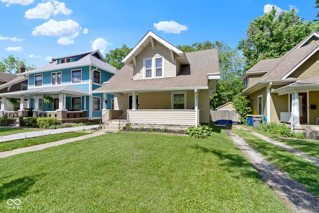 344 N Whittier Pl, Indianapolis, IN 46219 - view of front facade featuring covered porch, a front lawn, and a shingled roof