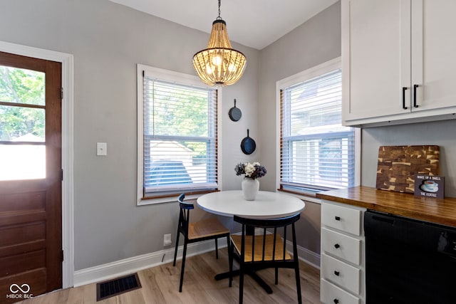 344 N Whittier Pl, Indianapolis, IN 46219 - dining room with a chandelier, healthy amount of natural light, light wood finished floors, and baseboards