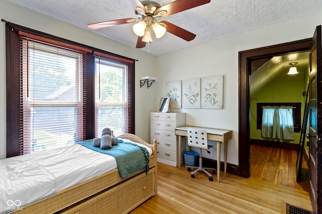 344 N Whittier Pl, Indianapolis, IN 46219 - bedroom featuring light wood-style flooring, a textured ceiling, and a ceiling fan