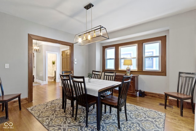 344 N Whittier Pl, Indianapolis, IN 46219 - dining area featuring wood finished floors, baseboards, and a chandelier