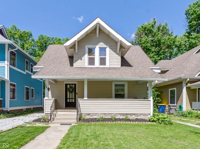 344 N Whittier Pl, Indianapolis, IN 46219 - bungalow with covered porch, a shingled roof, and a front lawn