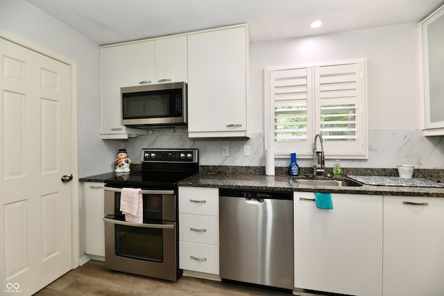 1310 Kings Cove Ct, Indianapolis, IN 46260 - kitchen with stainless steel appliances, a sink, white cabinetry, backsplash, and light wood finished floors