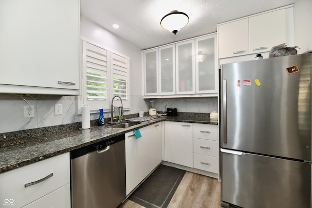 1310 Kings Cove Ct, Indianapolis, IN 46260 - kitchen with stainless steel appliances, a sink, white cabinetry, wood finished floors, and a textured ceiling