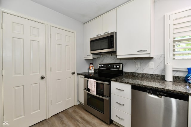 1310 Kings Cove Ct, Indianapolis, IN 46260 - kitchen with appliances with stainless steel finishes, light wood-style floors, white cabinetry, and tasteful backsplash