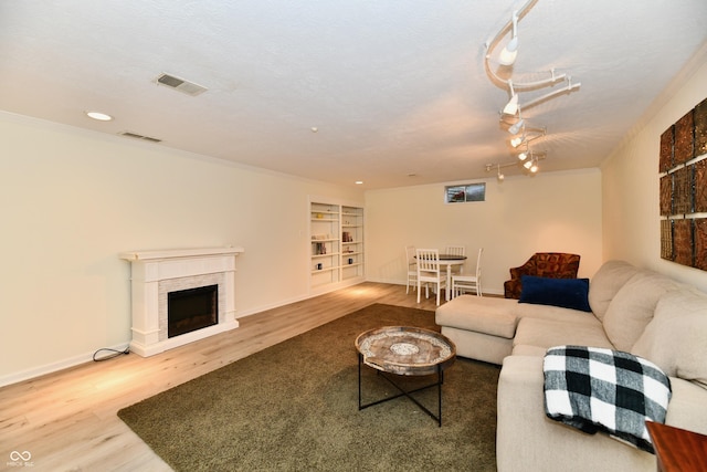 1310 Kings Cove Ct, Indianapolis, IN 46260 - living area featuring wood finished floors, built in features, a fireplace, baseboards, and crown molding