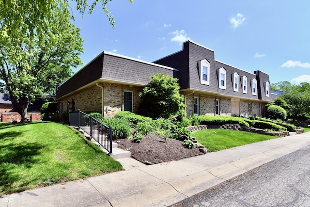 1310 Kings Cove Ct, Indianapolis, IN 46260 - front of property featuring mansard roof, brick siding, a front yard, and roof with shingles