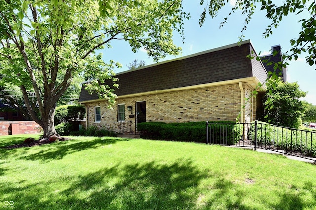 1310 Kings Cove Ct, Indianapolis, IN 46260 - view of home's exterior with brick siding, mansard roof, and roof with shingles