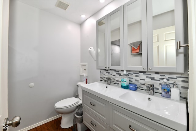 1310 Kings Cove Ct, Indianapolis, IN 46260 - bathroom featuring toilet, backsplash, wood finished floors, double vanity, and recessed lighting