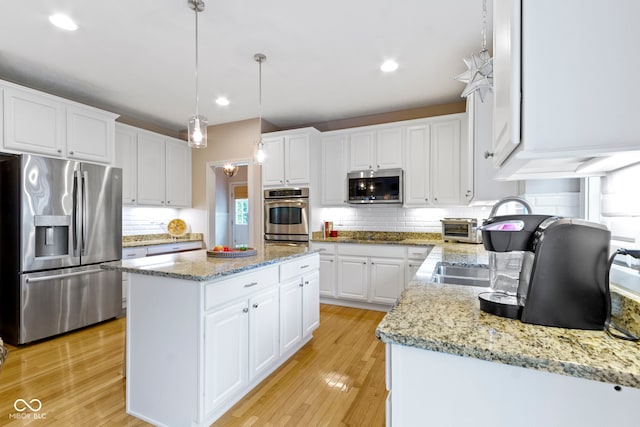 14094 Pecos Ct, Carmel, IN 46033 - kitchen with stainless steel appliances, a center island, backsplash, white cabinetry, and recessed lighting