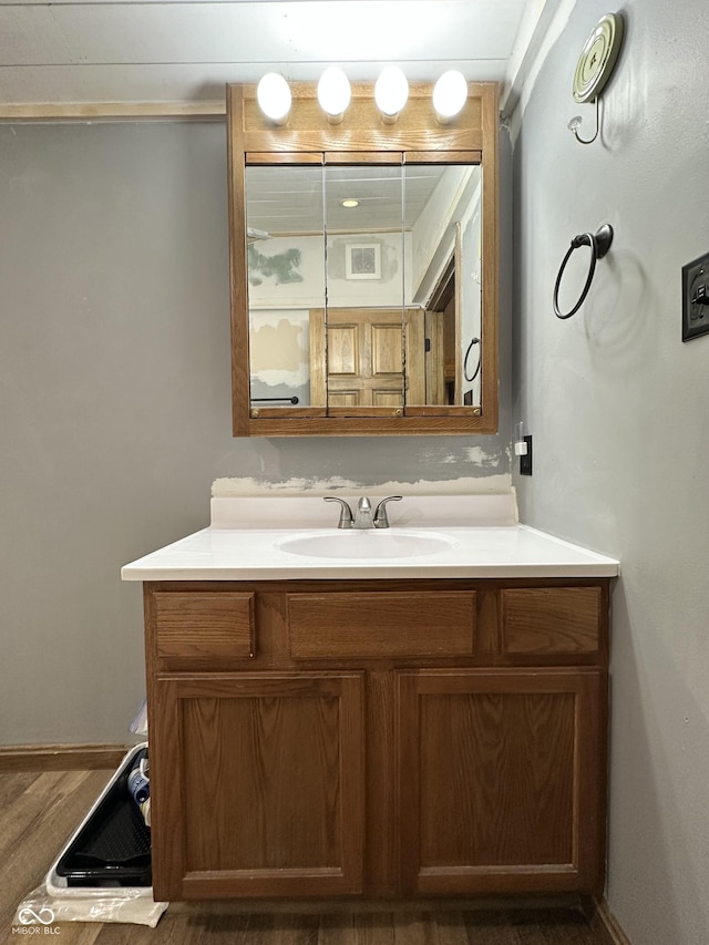 bathroom with vanity, wood finished floors, and baseboards