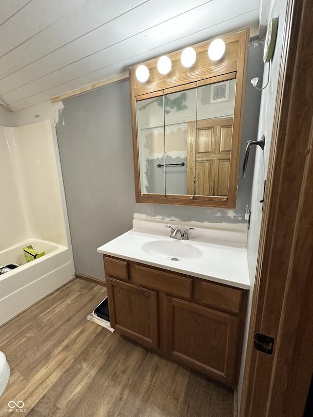 bathroom featuring wood finished floors, vanity, and a shower