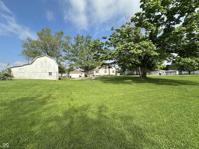 view of grassy yard featuring a barn and an outdoor structure