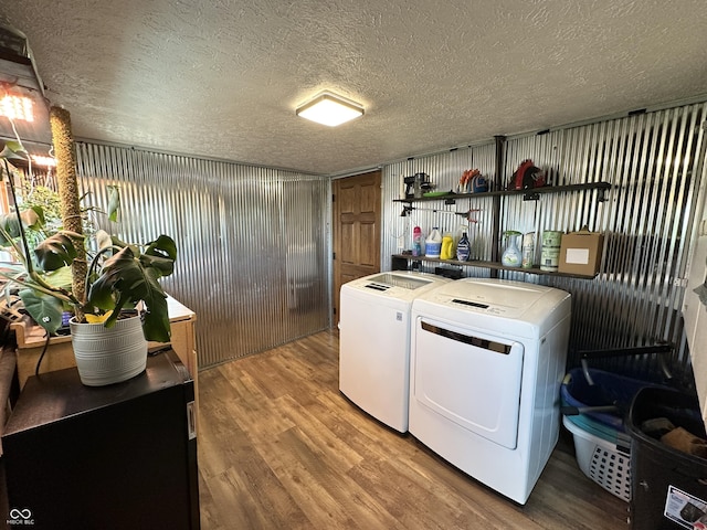 laundry area with independent washer and dryer, wood finished floors, and a textured ceiling