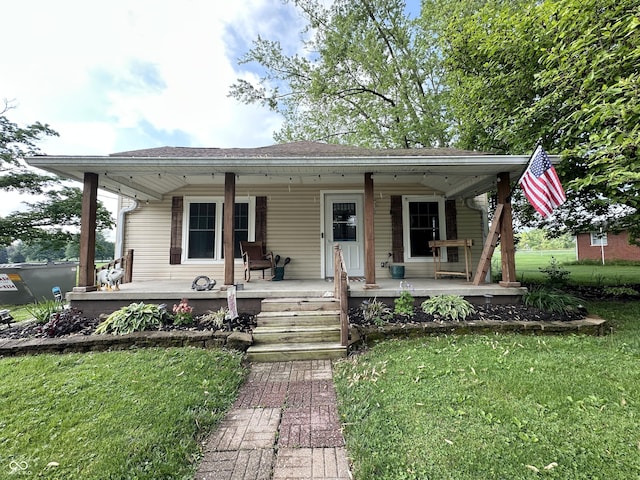 bungalow-style home featuring a front yard, a porch, and roof with shingles