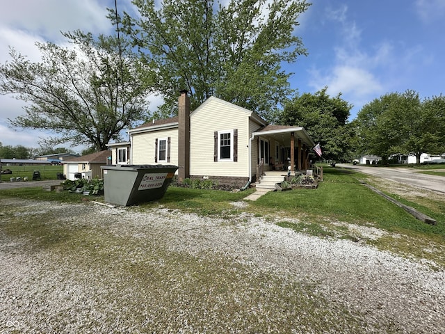 view of home's exterior with covered porch and a chimney