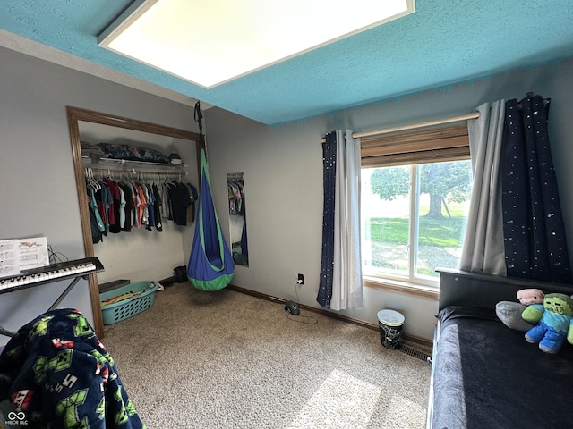 carpeted bedroom with a closet and baseboards