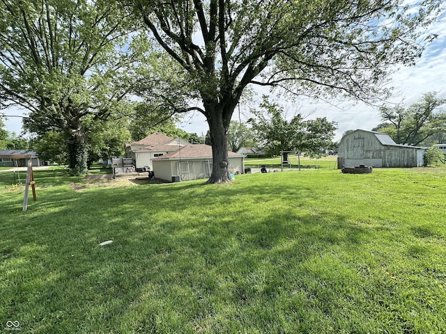 view of grassy yard with a barn and an outbuilding