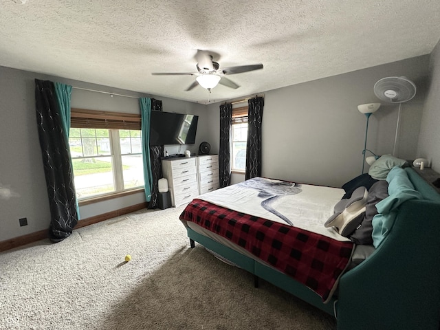 carpeted bedroom with baseboards, a ceiling fan, and a textured ceiling