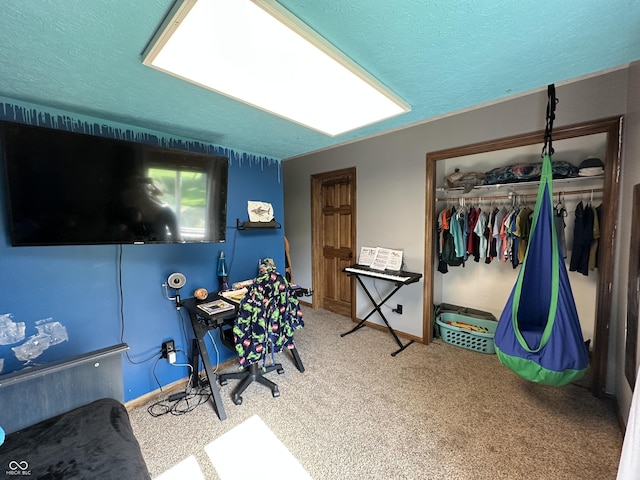 bedroom featuring a closet, a textured ceiling, carpet, and baseboards