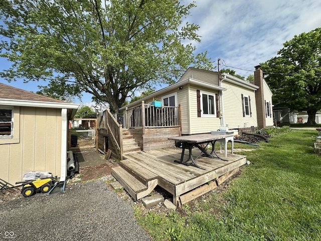back of house featuring a wooden deck and a yard