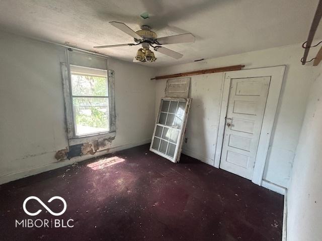 811 W 25th St, Indianapolis, IN 46208 - unfurnished bedroom featuring unfinished concrete flooring and ceiling fan